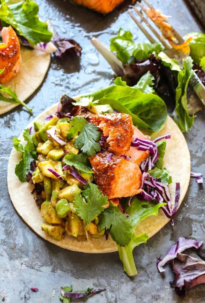 Overhead shot of BBQ salmon tacos with avocado salsa