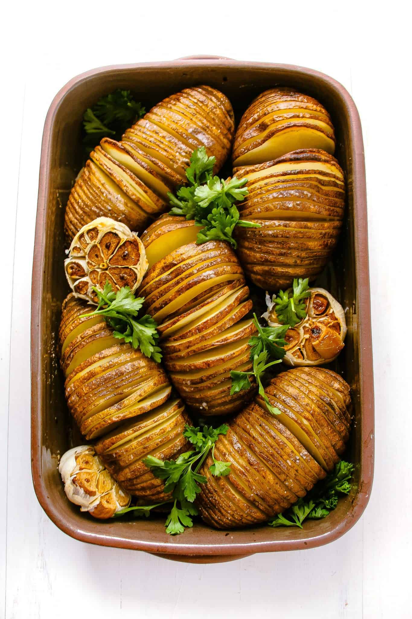 Hasselback potatoes with roasted garlic topped with fresh parsley