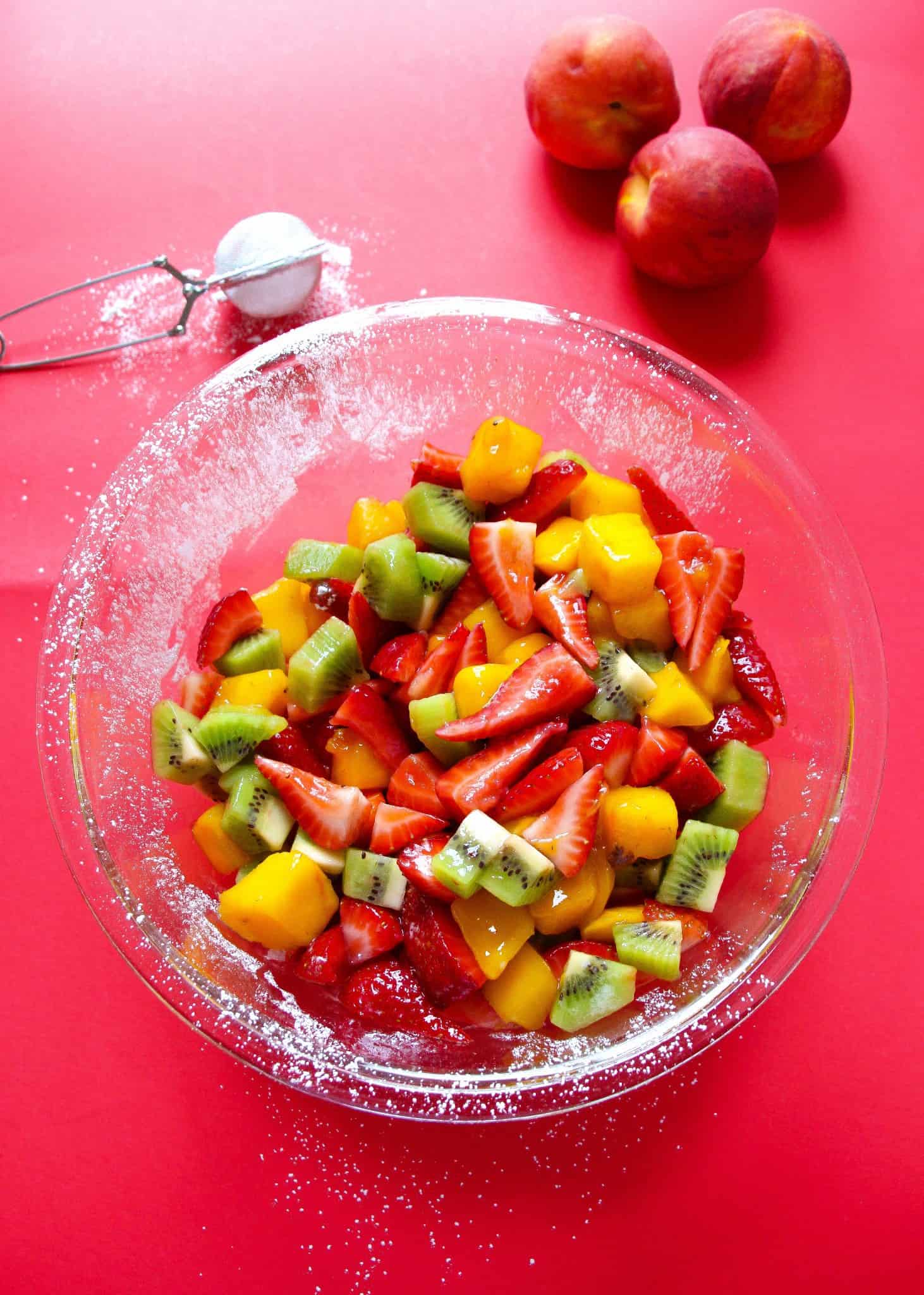 Fruit salad with strawberries, kiwis, mangoes and powdered sugar