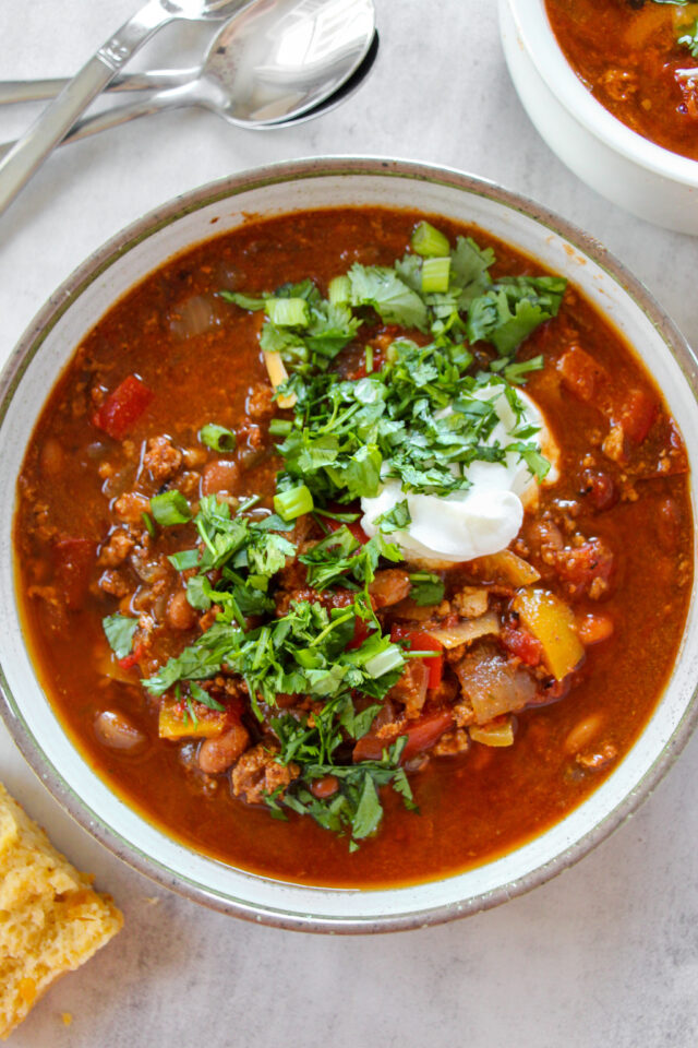 Mild Chili Recipe with cilantro, green onions and sour cream on top