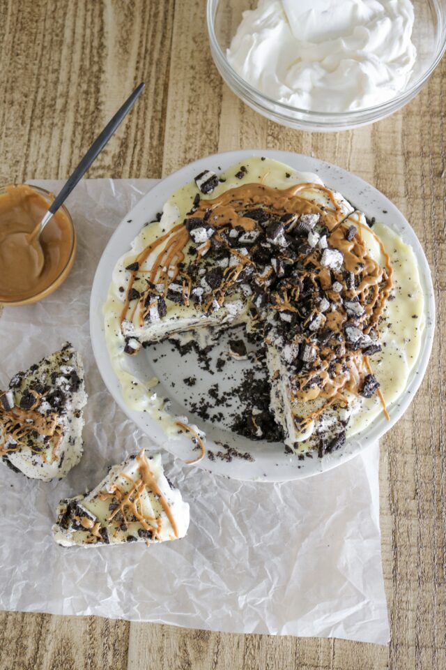 Cut slices of ice cream pie topped with crushed oreos and melted peanut butter