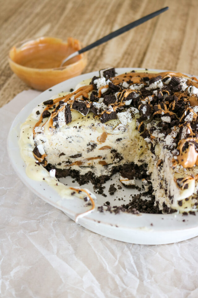 Cross section of an ice cream pie with an oreo crust that has chunks of peanut butter throughout