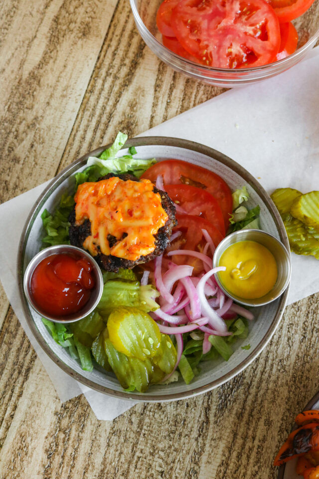 Overhead shot of deconstructed burgers with pimento cheese and pickled onions