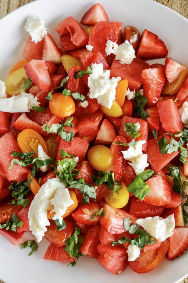 Close up photo of the watermelon strawberry caprese salad with fresh basil