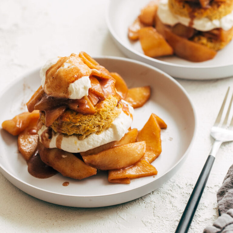 Pumpkin shortcakes plated with whipped cream and cinnamon apples