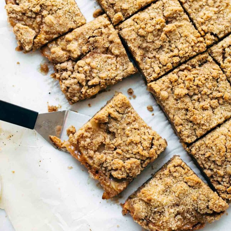 Cut caramel apple crisp bars with one on a spatula about to be served