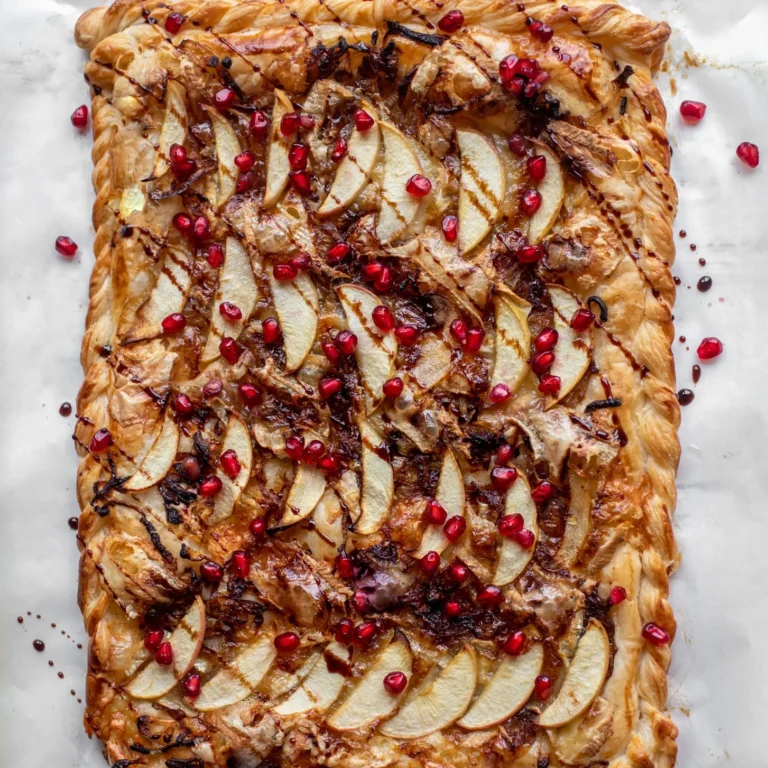 Overhead shot of the finished caramelized onion apple tart with pomegranates on top