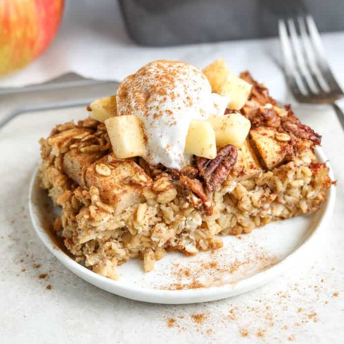 Apple pie baked oatmeal with whipped cream and cinnamon top
