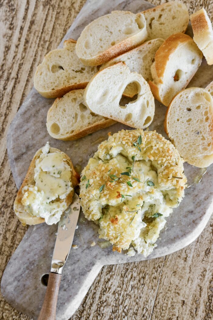 crispy baked boursin on a cheese board with sliced baguette