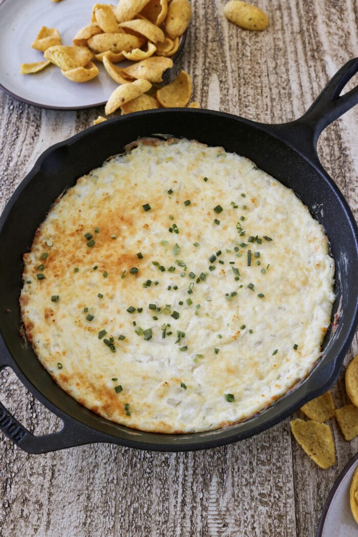 Hot Onion Dip in a cast iron with fritos on the side